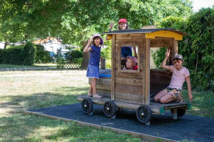 Enfants heureux jouant dans le petit train de camping
