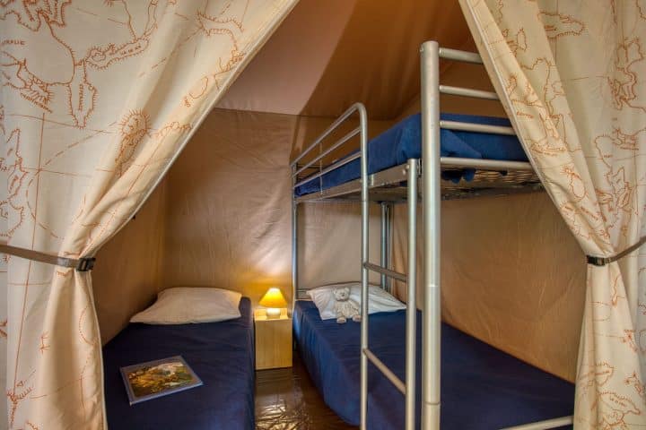 Chambre enfants avec lit superposé proche d'un lac de baignade en camping